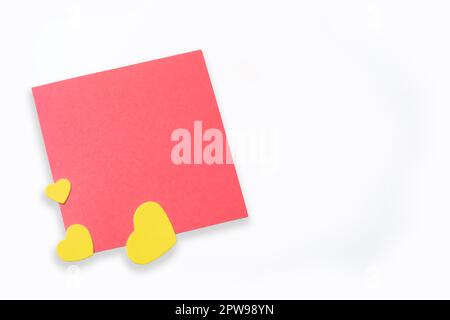 Nota in carta bianca con piccoli cuori gialli su sfondo bianco. Amore, matrimonio, San Valentino. Foto Stock
