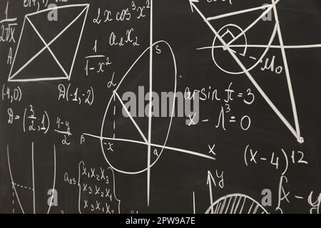 Diverse formule matematiche scritte con il gesso sulla lavagna Foto Stock