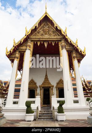 Questa foto cattura un piccolo edificio del tempio con intricati dettagli dorati sul tetto situato all'interno del complesso Wat Pho a Bangkok, Thailandia. Il complesso de Foto Stock