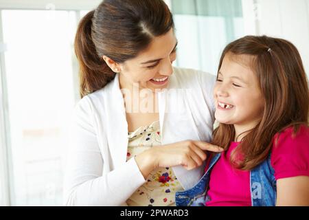 Im così fiero di VOI. Una giovane madre che stuzzica affettuosamente la figlia mentre si siede sul portico. Foto Stock