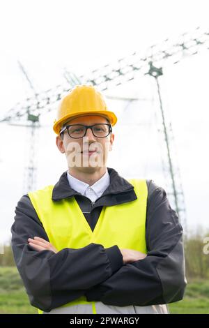 Ingegnere su uno sfondo di torre della linea elettrica. Foto di alta qualità Foto Stock