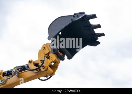 Primo piano della benna dell'escavatore su uno sfondo di cielo. Foto di alta qualità Foto Stock