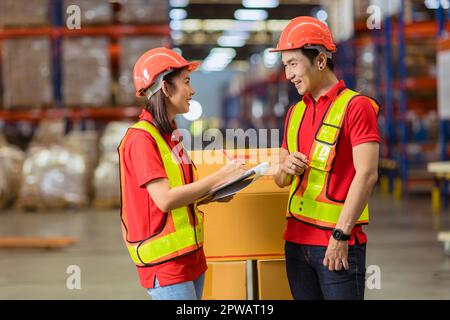 Il personale asiatico del magazzino della fabbrica apprezza la collaborazione. Lavoro del team di logistica per la spedizione dell'inventario delle merci Foto Stock