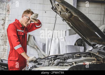 Stanco esaurito meccanico maschio personale fatica lavoro in caldo posto di lavoro problema di servizio auto duro lavoro Foto Stock