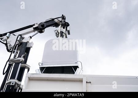 Il camion dei rifiuti solleva il cassone per rifiuti riciclabili. Foto di alta qualità Foto Stock