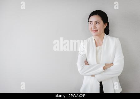 Senior adulto Asian businesswoman leader dirigente titolare di società in piedi fiducioso cercando la visione con lo spazio copia Foto Stock