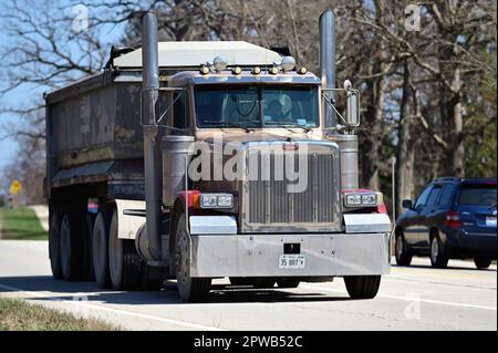Streamwood, Illinois, Stati Uniti. Un camion che passa attraverso una zona boschiva fiancheggiata da foreste preserva terreni e suddivisioni residenziali. Foto Stock