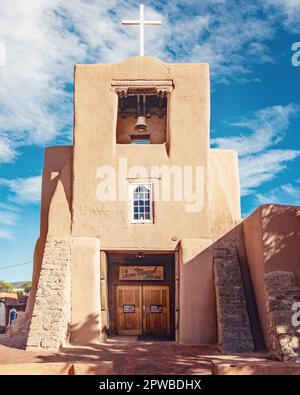 La storica chiesa della missione San Miguel di santa Fe, New Mexico, con campanile, croce bianca e porta di legno. Foto Stock