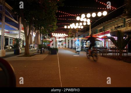 Tauranga Nuova Zelanda - Aprile 27 2023; via Tauranga di notte con luci e tenebre. Nel quartiere dei ristoranti di Wharf Street con immagini sfocate di ciclis Foto Stock
