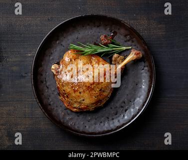 piatto di confit gamba d'anatra su tavolo nero, vista dall'alto Foto Stock