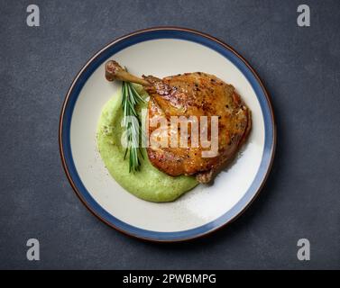 piatto di confit gamba d'anatra e purea di broccoli, vista dall'alto Foto Stock