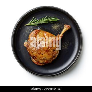 confit gamba d'anatra su piastra nera isolata su sfondo bianco, vista dall'alto Foto Stock