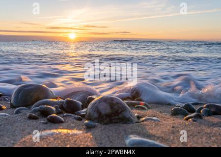 Da sogno, arancio, tramonto tra le rocce nel mare del Mar Baltico vicino a Dranske sull'isola di Rügen Foto Stock