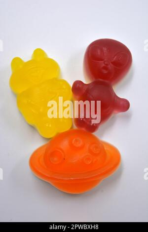 Dolci in forma di alieni rossi e gialli, razzi spazio ciliegia, astronauti verdi, navi aliene rosa e un pianeta arancione, asteroidi. Foto Stock