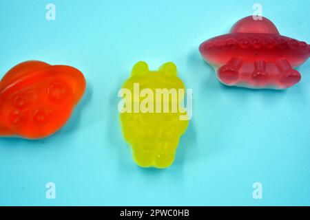 Dolci in forma di alieni rossi e gialli, razzi spazio ciliegia, astronauti verdi, navi aliene rosa e un pianeta arancione, asteroidi. Foto Stock