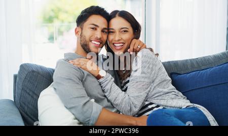 Trovarono pezzi delle loro anime l'uno nell'altro. Ritratto corto di una giovane coppia affettuosa che si tiene mentre nel loro salotto durante Foto Stock