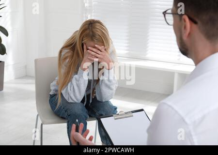 Psicoterapeuta che lavora con una giovane donna tossicodipendente in ambienti chiusi Foto Stock