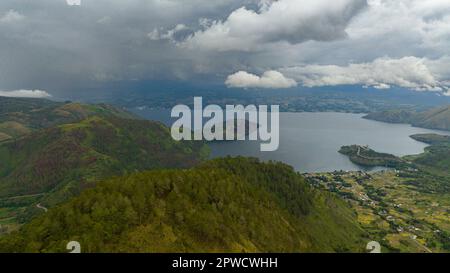 Drone aereo del lago Toba e dell'isola di Samosir. tra le montagne con vegetazione tropicale. Sumatra, Indonesia. Foto Stock