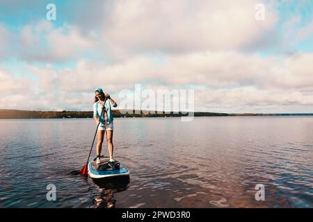 Non saprai mai fino a quando non andrai. una giovane donna pagaia imbarco su un lago. Foto Stock