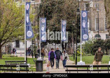 Londra, Regno Unito. 12th Apr, 2023. La gente passa davanti alla bandiera dell'incoronazione di Re Carlo III in Russell Square prima della sua incoronazione a Londra, Gran Bretagna, 30 aprile 2023. L'incoronazione britannica di Kingís è il 6th maggio. Credit: SOPA Images Limited/Alamy Live News Foto Stock