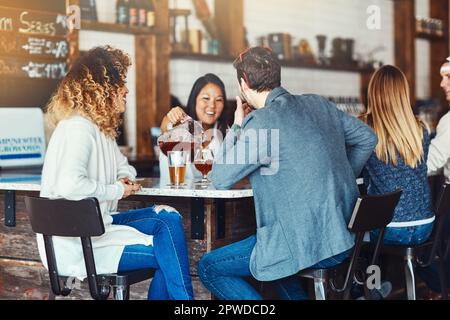 Versare e godere. una giovane donna che serve bevande in un bar. Foto Stock