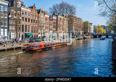 AMSTERDAM, OLANDA - 17 APRILE 2023: I Toursts Godetevi una gita in barca lungo un canale ad Amsterdam, capitale dei Paesi Bassi Foto Stock