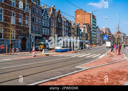 AMSTERDAM, OLANDA - 17 APRILE 2023: Vista sulla strada di Amsterdam, capitale olandese conosciuta per il suo elaborato sistema di canali, case strette e ciclismo Foto Stock