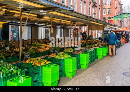 AMSTERDAM, OLANDA - 18 APRILE 2023: Acquirenti che acquistano prodotti freschi al mercato locale di Street food a Katestraat ad Amsterdam. Foto Stock