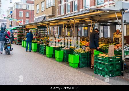 AMSTERDAM, OLANDA - 18 APRILE 2023: Acquirenti che acquistano prodotti freschi al mercato locale di Street food a Katestraat ad Amsterdam. Foto Stock