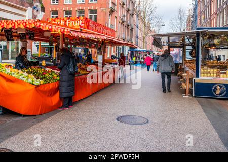 AMSTERDAM, OLANDA - 18 APRILE 2023: Acquirenti che acquistano prodotti freschi al mercato locale di Street food a Katestraat ad Amsterdam. Foto Stock