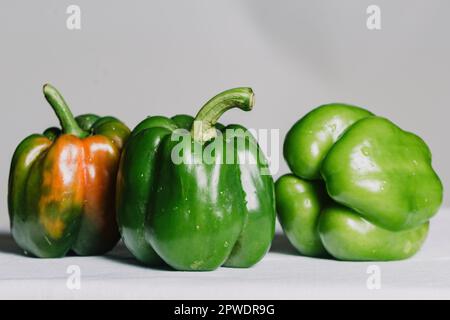 Pomodoro fresco intero e peperone rosso giallo isolato su fondo bianco. Foto Stock