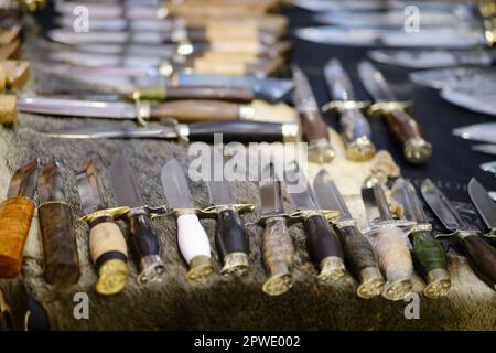 Molti coltelli sono disposti sulla piattaforma. Coltelli dell'esercito per i militari, set Foto Stock