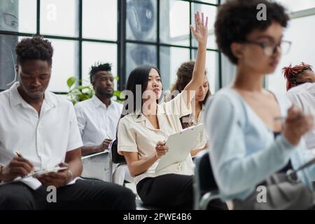 Gruppo di diversi dipendenti che studiano durante le riunioni del consiglio di amministrazione in un moderno ufficio o sala conferenze Foto Stock