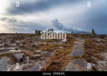Deirbhile's Twist un moderno cerchio di pietra sotto un cielo tempestoso a Falmore nella contea di Mayo in Irlanda Foto Stock