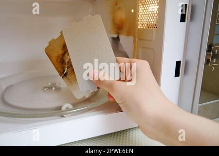 Riparazione di un forno a microonde frizzante sostituendo la piastra di mica.  Forno a microonde rotto con foglio di mica autosostituto Foto stock - Alamy