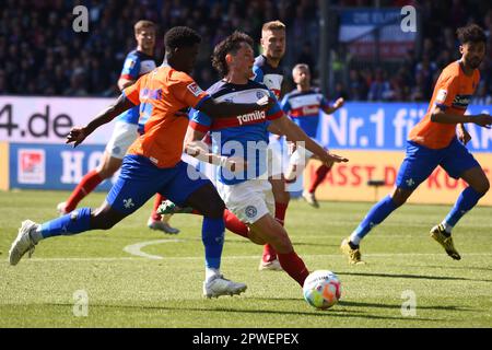 30 aprile 2023, Schleswig-Holstein, Kiel: Calcio: 2nd Bundesliga, Holstein Kiel - Darmstadt 98, Giornata 30, Stadio Holstein. Braydon Manu di Darmstadt (a sinistra) e Fabian Reese di Kiel gareggia per la palla. Foto: Gregor Fischer/dpa - NOTA IMPORTANTE: Conformemente ai requisiti della DFL Deutsche Fußball Liga e della DFB Deutscher Fußball-Bund, è vietato utilizzare o utilizzare fotografie scattate nello stadio e/o della partita sotto forma di sequenze di immagini e/o serie di foto simili a un video. Foto Stock