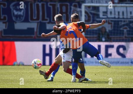 30 aprile 2023, Schleswig-Holstein, Kiel: Calcio: 2nd Bundesliga, Holstein Kiel - Darmstadt 98, Giornata 30, Stadio Holstein. La pinna di Kiel Bartels (l) e Braydon Manu di Darmstadt combattono per la palla nel centrocampo. Foto: Gregor Fischer/dpa - NOTA IMPORTANTE: Conformemente ai requisiti della DFL Deutsche Fußball Liga e della DFB Deutscher Fußball-Bund, è vietato utilizzare o utilizzare fotografie scattate nello stadio e/o della partita sotto forma di sequenze di immagini e/o serie di foto simili a un video. Foto Stock