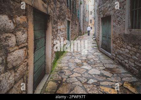 Pittoresca, stretta, stradina acciottolata nella storica città medievale di Sibenik, Croazia. Foto Stock