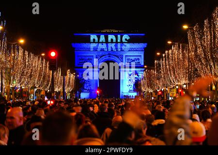 Parigi, Francia - 1st gennaio 2023 : la folla si è riunita sugli Champs Elysées a Parigi per celebrare il passaggio al 2023 con uno spettacolo di fuochi d'artificio sull'Arco Foto Stock