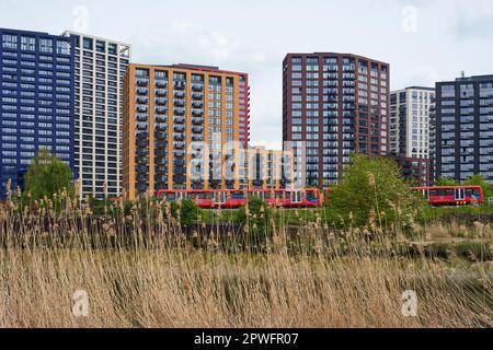 Il nuovo complesso di appartamenti London City Island e un treno Docklands Light Railway, visto dalle rive del fiume Lea, East London UK Foto Stock