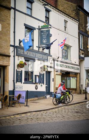 Due ciclisti anziani fuori dal Woolley Sheep Inn su Sheep Street, Skipton, la mattina presto della domenica Foto Stock