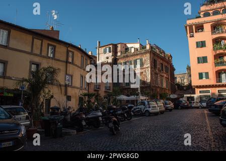 Roma, vista su una tranquilla piazza residenziale sul Lungotevere, con appartamenti, balconi, auto e biciclette parcheggiate, bar e ristorante all'aperto Foto Stock