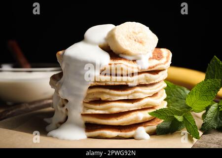 Gustose frittelle con banana a fette servite sul tavolo, primo piano Foto Stock