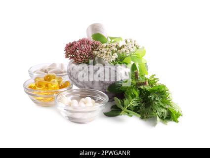 Mortaio di marmo con erbe fresche e pillole su sfondo bianco Foto Stock