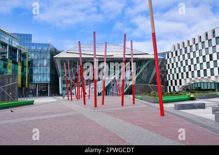 Piazza pubblica circondata da bassi e moderni edifici di uffici nell'area Docklands di Dublino vicino al Canal Grande Foto Stock