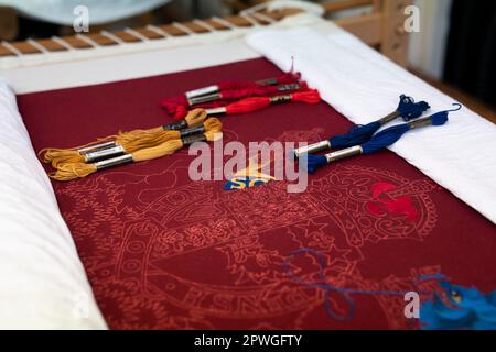 Particolare di una copertura per sedia a trono, dove Re Carlo III e la Regina Consort visitarono il Royal College of Needlework all'Hampton Court Palace a East Molesey, Surrey. Data immagine: Martedì 21 marzo 2023. Foto Stock