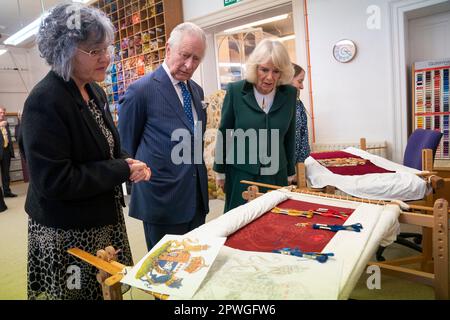 Re Carlo III e la Regina Consort guardano le loro coperture del trono durante una visita al Royal College of Needlework all'Hampton Court Palace a East Molesey, Surrey. Data immagine: Martedì 21 marzo 2023. Foto Stock