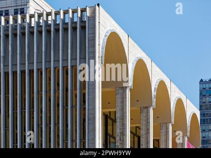 Tre lati del Metropolitan Opera House del Lincoln Center sono rivestiti in vetro dietro le pareti di alte pinne di travertino verticali. Foto Stock