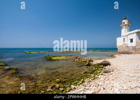 Faro e spiaggia, punta settentrionale della penisola, Mar mediterraneo, antica colonna di pietra sott'acqua, Tiro (Sour, sur), Libano, Medio Oriente, Asia Foto Stock