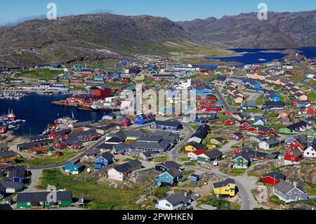 Vista su una piccola città, campo da calcio, aspro paesaggio montano, Qaqortoq, comune di Kujalleq, Artico, Groenlandia, Danimarca Foto Stock